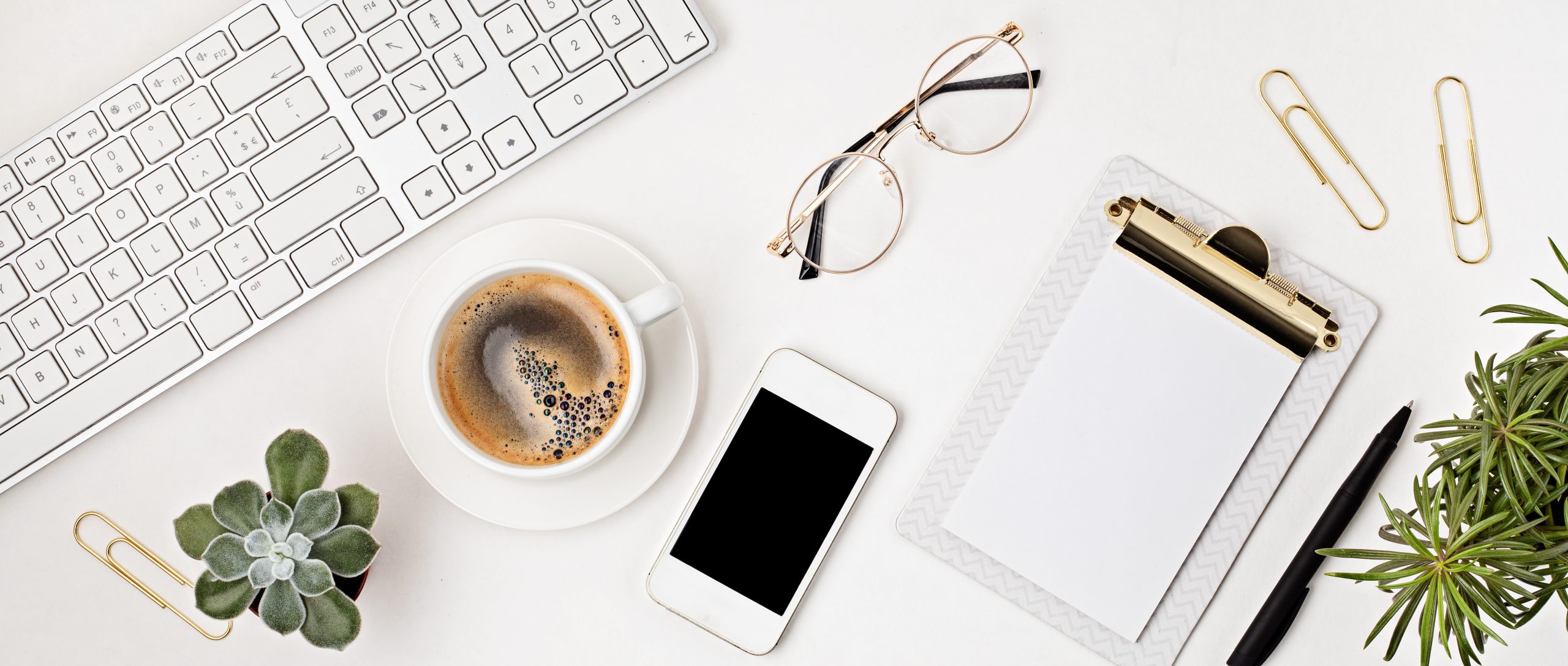 Top view of office desk. Table with keyboard, smartphone, clipboard and office supplies. Flat lay home office workspace, remote work, distant learning, video conference, calls idea. Banner
